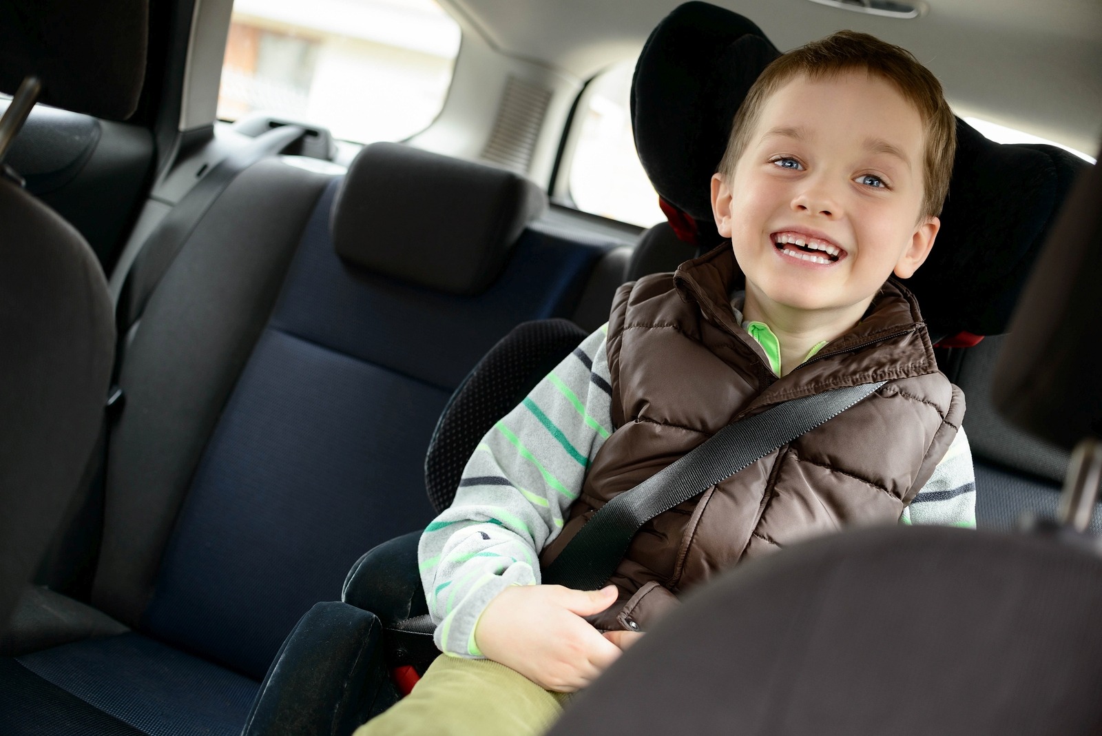 Happy little boy in car safety seat. Children car safety concept ...